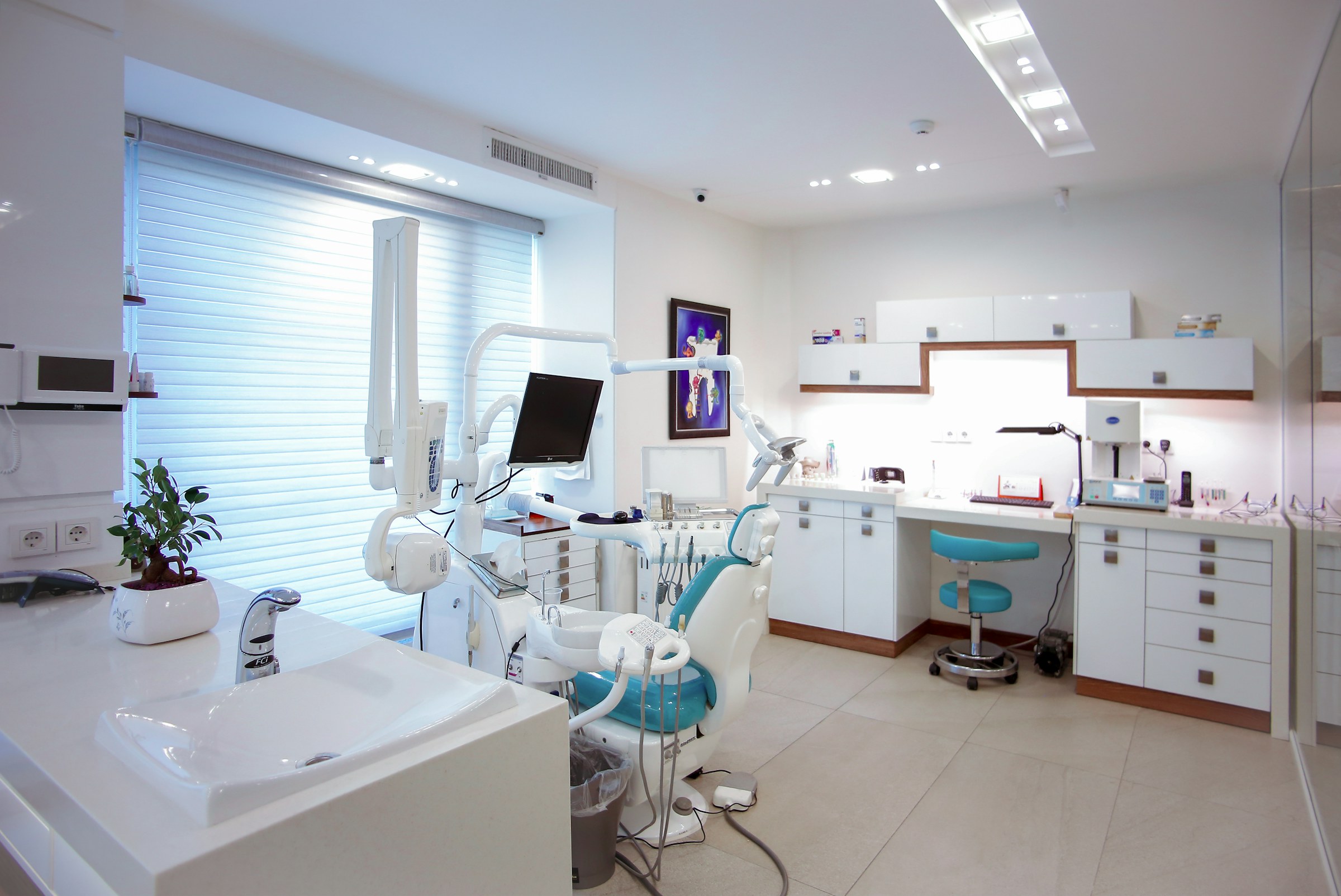 Modern dental treatment room equipped with a dental unit and overhead light